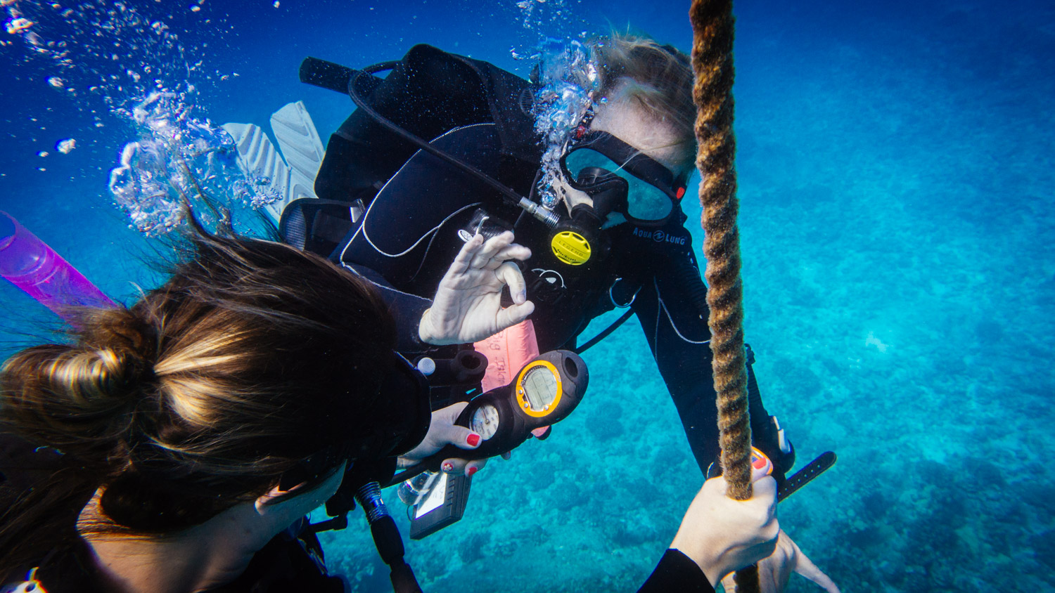 Are you for scuba? Instructor Brooke checks with her student on a descent line.